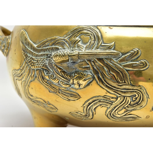 277 - A CHINESE BRASS TWIN HANDLED TRIPOD CENSER OF CIRCULAR FORM, cast in relief with four dragons, the i... 