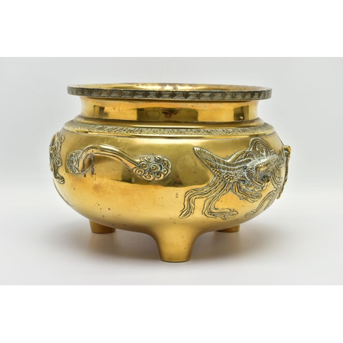 277 - A CHINESE BRASS TWIN HANDLED TRIPOD CENSER OF CIRCULAR FORM, cast in relief with four dragons, the i... 