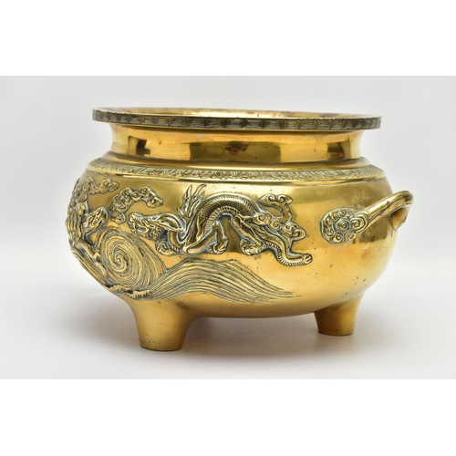 277 - A CHINESE BRASS TWIN HANDLED TRIPOD CENSER OF CIRCULAR FORM, cast in relief with four dragons, the i... 