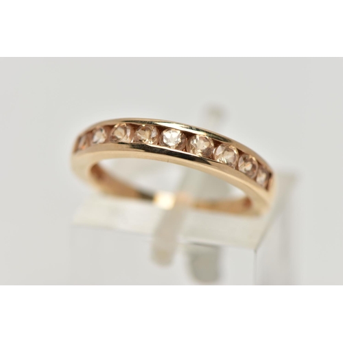 106 - A 9CT GOLD GEM SET HALF ETERNITY RING, the circular shape peachy colour gems assessed as tourmaline,... 