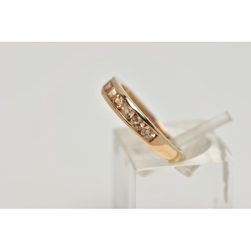 106 - A 9CT GOLD GEM SET HALF ETERNITY RING, the circular shape peachy colour gems assessed as tourmaline,... 