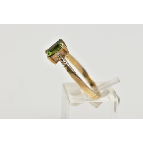 12 - A 9CT GOLD PERIDOT AND DIAMOND DRESS RING, the rectangular shape peridot, within a claw setting, to ... 
