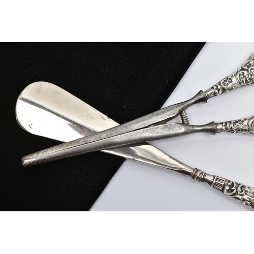 34 - A SILVER HANDLED SHOEHORN AND GLOVE STRETCHERS, a matching set detailing a scrolling foliage design,... 