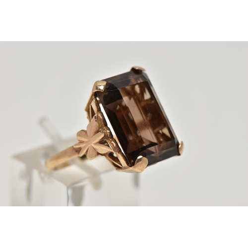 86 - A 9CT GOLD SMOKEY QUARTZ DRESS RING, a four claw set large rectangular cut smokey quartz, openwork g... 