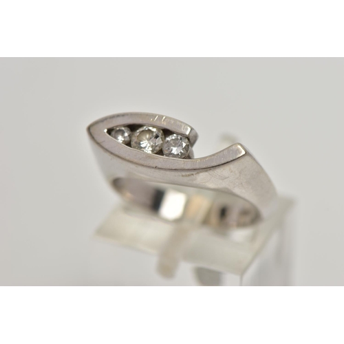89 - A WHITE METAL DIAMOND RING, the ring head of an abstract lozenge shape, set with three graduated rou... 