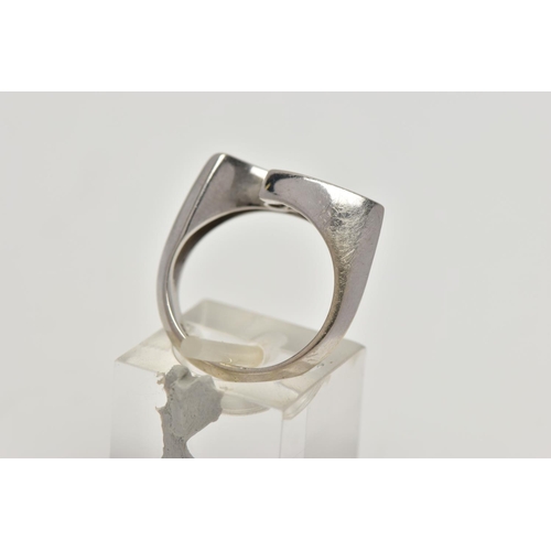 89 - A WHITE METAL DIAMOND RING, the ring head of an abstract lozenge shape, set with three graduated rou... 