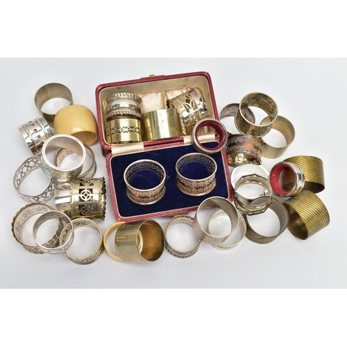 106 - AN ASSORTMENT OF WHITE METAL NAPKIN RINGS, to include a pair of cased napkin rings pierced circular ... 