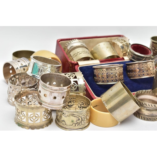 106 - AN ASSORTMENT OF WHITE METAL NAPKIN RINGS, to include a pair of cased napkin rings pierced circular ... 