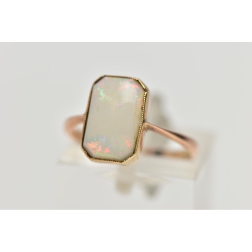 15 - A YELLOW METAL OPAL RING, rectangular cut opal cabochon with cut off corners, milgrain collet mount,... 