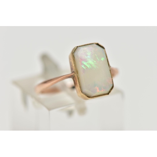 15 - A YELLOW METAL OPAL RING, rectangular cut opal cabochon with cut off corners, milgrain collet mount,... 