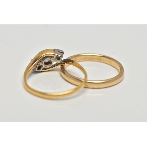 23 - TWO GOLD RINGS, the first a yellow metal three stone cross over ring, designed with a central round ... 