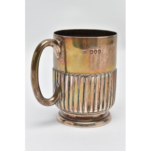 93 - A SILVER MUG, stop reeded pattern, raised on a round base, fitted with a curved handle, worn gilt, h... 