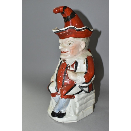 435 - A STAFFORDSHIRE TOBY JUG IN THE FORM OF MR PUNCH, with red, black and white striped outfit, the hat ... 