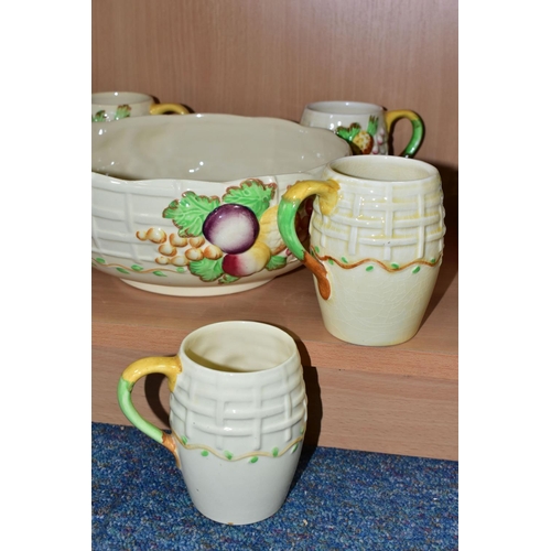 441 - A CLARICE CLIFF 'FRUIT BASKET' FRUIT BOWL AND FOUR MUGS, with relief moulded fruits and basketweave ... 