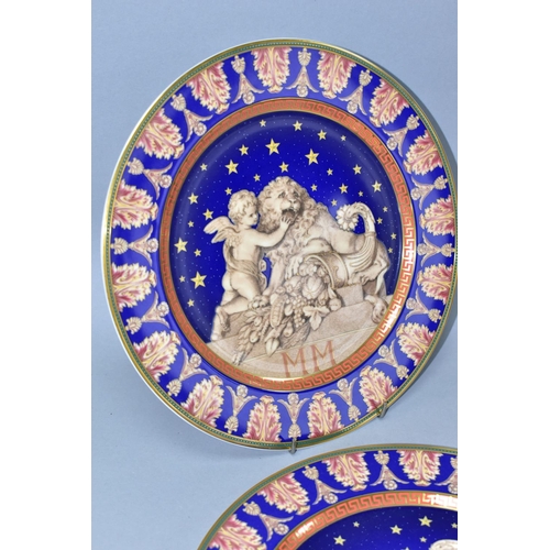 527 - TWO ROSENTHAL FOR VERSACE CHRISTMASTIDE 2000 PLATES, depicting a cherub, lion and cornucopia statue ... 