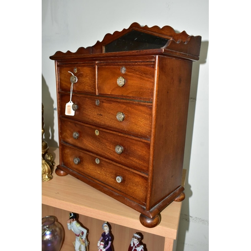 582 - A MINIATURE MAHOGANY CHEST OF DRAWS WITH GALLERIED MIRROR, having two short draws over three long dr... 