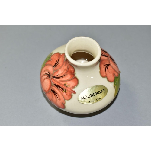 586 - A SMALL MOORCROFT ORANGE HIBISCUS PATTERN VASE, of squat baluster form, foil label to the side, appr... 