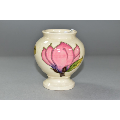 590 - A MOORCROFT PINK MAGNOLIA PATTERN, URN SHAPED VASE, approximate height 9cm, gold foil label to the b... 