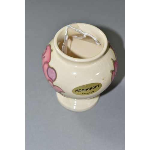 590 - A MOORCROFT PINK MAGNOLIA PATTERN, URN SHAPED VASE, approximate height 9cm, gold foil label to the b... 