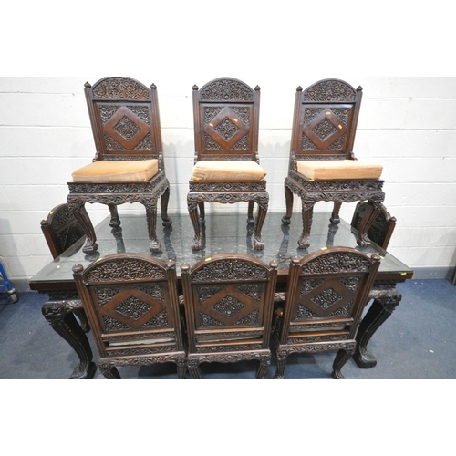 1191 - A 20TH CENTURY THAI ORIENTAL HEAVILY CARVED STAINED TEAK DINING TABLE, the recessed top with a repea... 