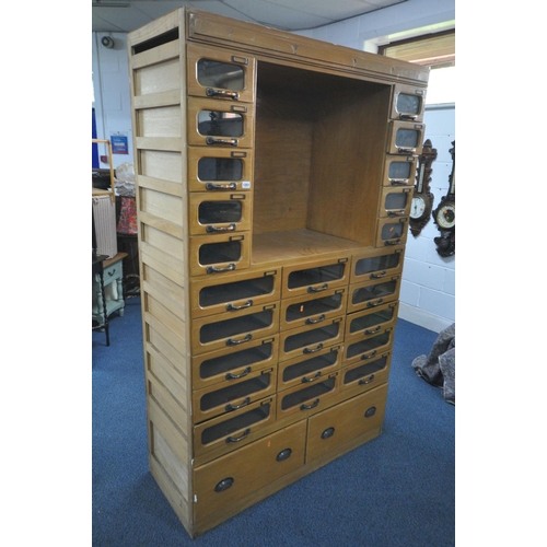 1201 - A MID-CENTURY BEECH HABERDASHERY CABINET, made up of two banks of five glass front drawers that's fl... 