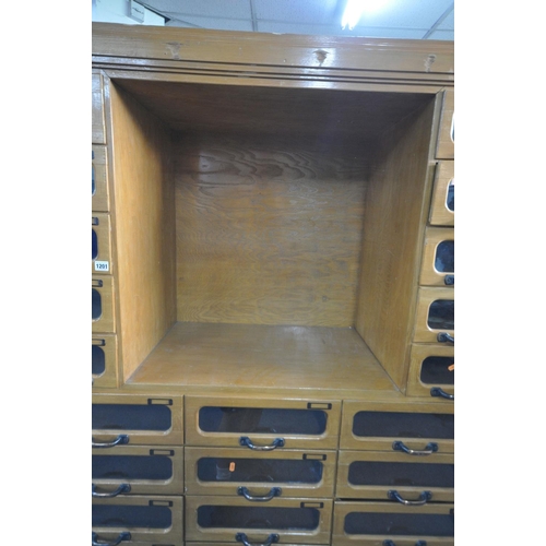 1201 - A MID-CENTURY BEECH HABERDASHERY CABINET, made up of two banks of five glass front drawers that's fl... 