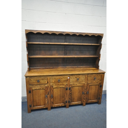 1224 - A REPRODUCTION OAK DRESSER, with a two tier plate rack, four drawers, and four panelled cupboard doo... 