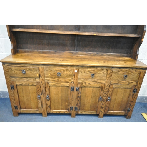 1224 - A REPRODUCTION OAK DRESSER, with a two tier plate rack, four drawers, and four panelled cupboard doo... 