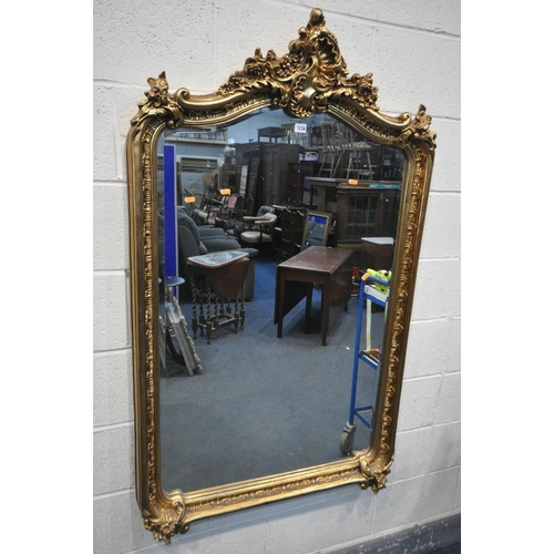 1236 - A LARGE GILT RESIN BEVELLED EDGE FRENCH WALL MIRROR, the top with foliate carving and detailing (con... 