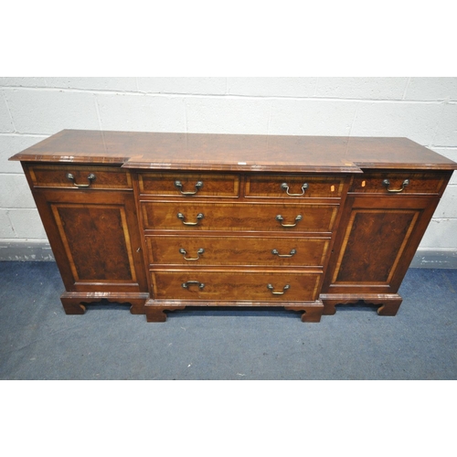 1250 - A YEW WOOD BREAKFRONT SIDEBOARD, with seven assorted drawers, and two cupboard doors, length 185cm x... 