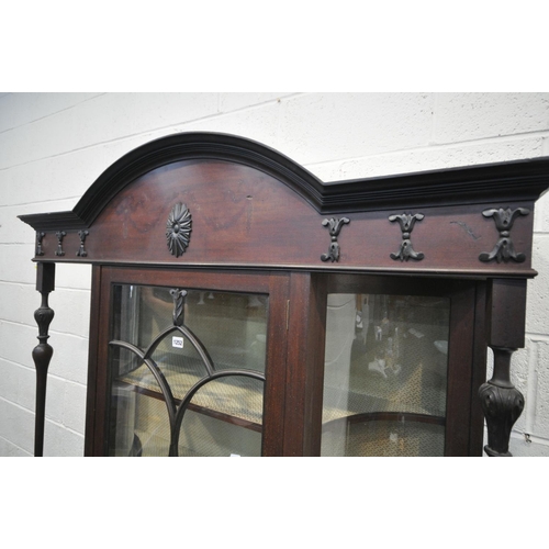 1252 - AN EARLY 20TH CENTURY MAHOGANY DISPLAY CABINET,  with concave glass panels, and turned supports, fla... 