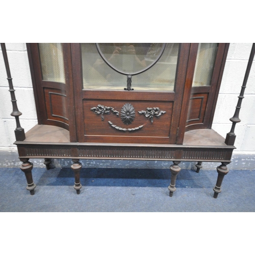 1252 - AN EARLY 20TH CENTURY MAHOGANY DISPLAY CABINET,  with concave glass panels, and turned supports, fla... 