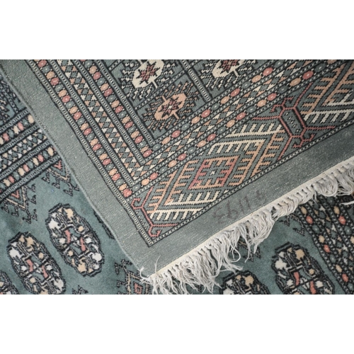 1254 - A KAYAM PAKISTAN TEAL GROUND RUG, with a multistrap border, and eighty four medallions, length 250cm... 