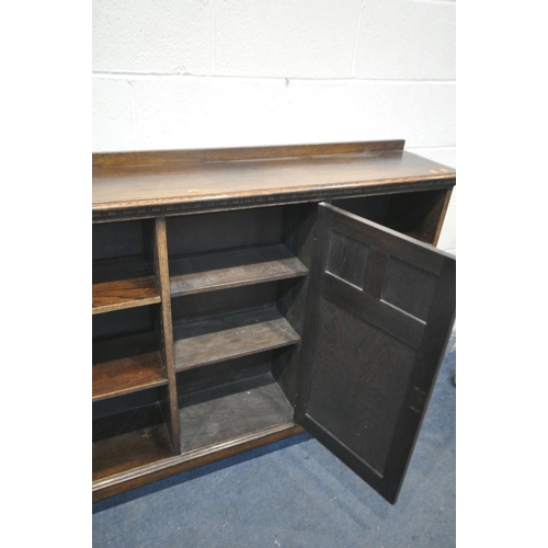 1256 - AN EARLY TO MID 20TH CENTURY OAK SIDE BY SIDE BOOKCASE, with a raised back, a single central door, a... 