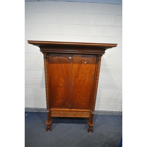 1263 - AN INDONESIAN HARDWOOD TWO DOOR WARDROBE, with a large over hanging cornice, twin twisted pillars, w... 