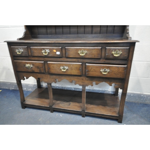 1284 - A REPRODUCTION OAK DRESSER, with a three tier plate rack, above a base with seven assorted drawers, ... 