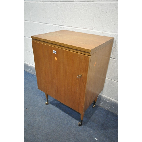 1298 - A MID CENTURY TEAK SEWING CABINET. with a fold over top and single door, enclosing a rise and fall m... 