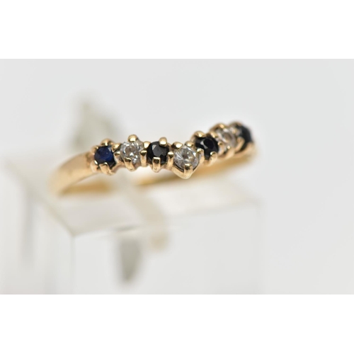 11 - A 9CT GOLD GEM SET WISH BONE RING, designed with a row of four claw set, circular cut sapphires inte... 