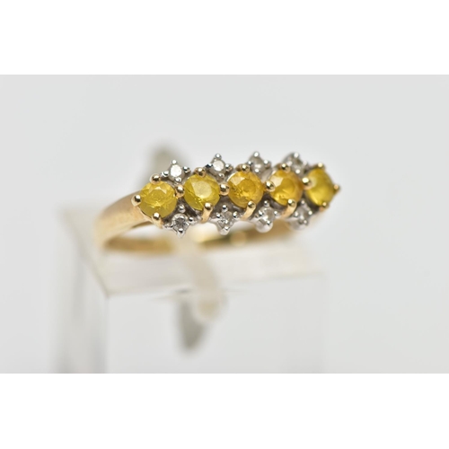 12 - A 9CT GOLD GEM SET RING, designed with a central row of five circular cut yellow stones assessed as ... 