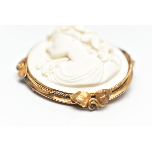 136 - A YELLOW METAL LAVA CAMEO BROOCH, the cameo carved to depict a lady in profile with floral detail to... 