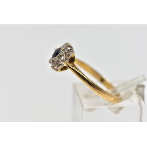 56 - A YELLOW AND WHITE METAL CLUSTER RING, a circular cut sapphire and six single cut diamonds prong set... 