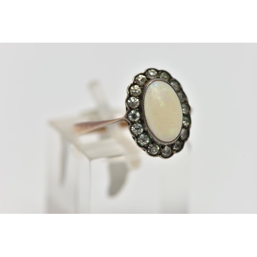 65 - A MID 20TH CENTURY OPAL AND PASTE CLUSTER RING, set with a principal oval opal cabochon, within a co... 