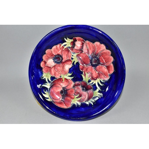 411 - A MOORCROFT POTTERY COMPORT, in the Anemone pattern, tubelined with red anemones on a dark blue grou... 