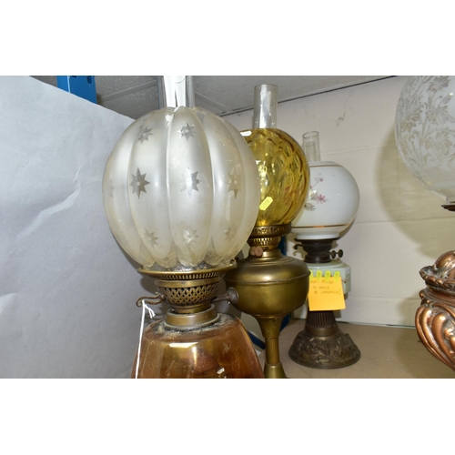 528 - FOUR EARLY 20TH CENTURY OIL LAMPS, comprising a metal based lamp with  hand painted  flowers on a ce... 