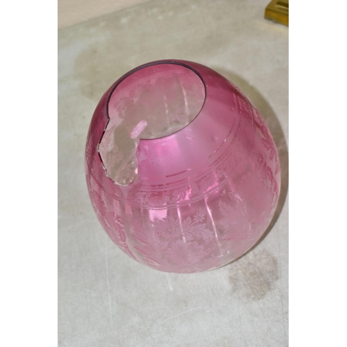 605 - A LATE VICTORIAN OIL LAMP, the acid etched cranberry glass shade with broken section, cranberry rese... 