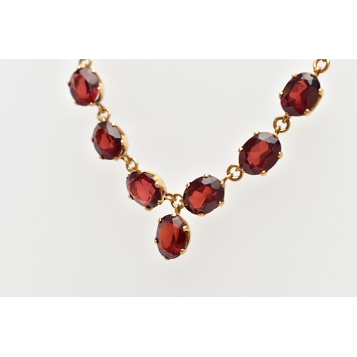 112 - A YELLOW METAL RED PASTE NECKLACE, comprising a series of oval cut red pastes, with a similarly cut ... 