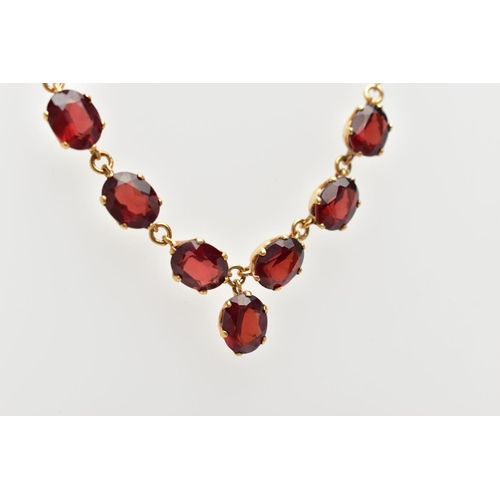 112 - A YELLOW METAL RED PASTE NECKLACE, comprising a series of oval cut red pastes, with a similarly cut ... 