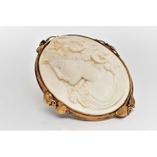 187 - A YELLOW METAL LAVA CAMEO BROOCH, the cameo carved to depict a lady in profile with floral detail to... 