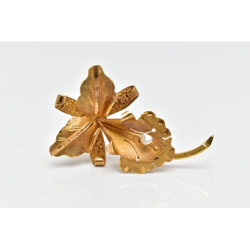 62 - A YELLOW METAL FLOWER BROOCH, a floral brooch detailing a flower, leaves and stem, set with a single... 