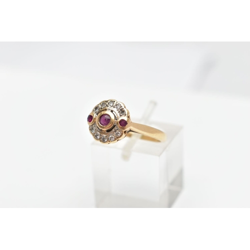 68 - A 14CT GOLD RUBY AND DIAMOND RING, designed with a central circular cut ruby collet set, flanked wit... 